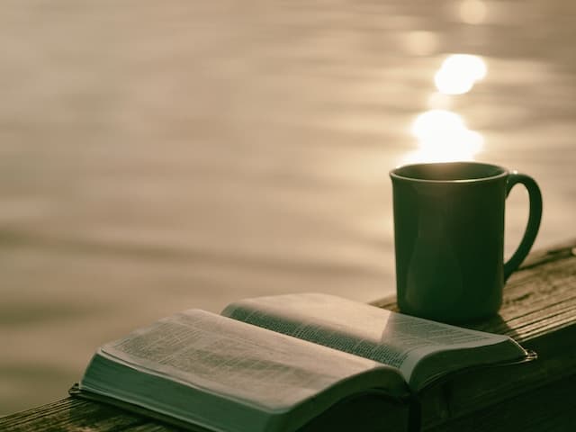 A book beside a cup