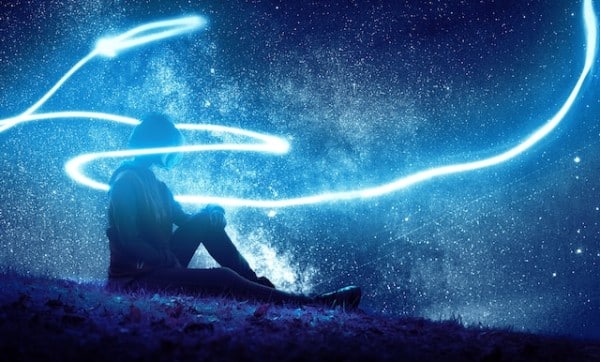 Girl seated on grass with a blue light around her