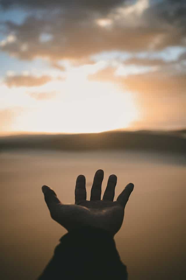 Hand with sunset in background