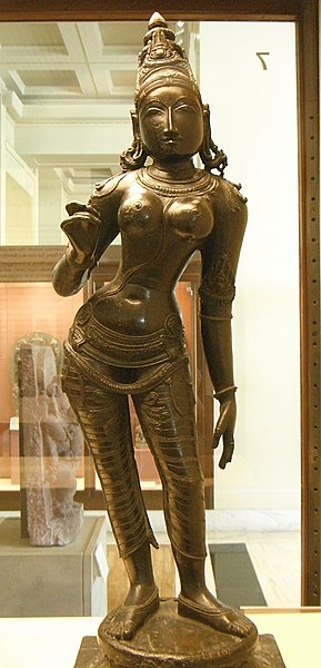 The consort of Shiva is shown in this bronze sculpture as a beautiful young woman. Her pose is the classic tribhanga, in which the body is bent in three directions - from the legs; the trunk and neck.